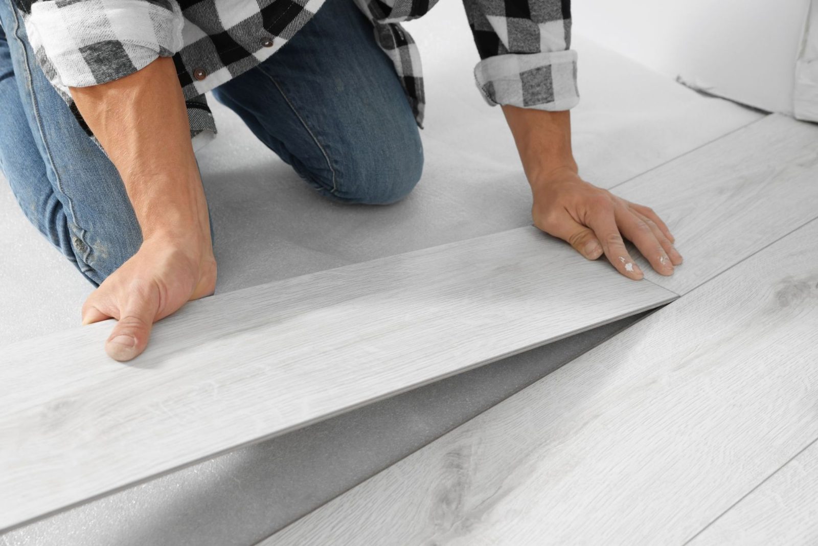 Flooring contractor installing vinyl plank over a prepared subfloor
